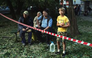 A boy in the yard near a house hit by a rocket in the Solomianskyi district of Kyiv