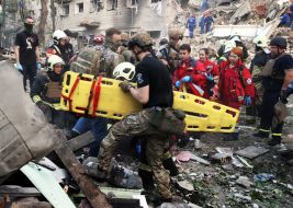 Providing assistance to a State Emergency Service employee near a residential building destroyed as a result of a direct missile hit in the Solomianskyi district of Kyiv