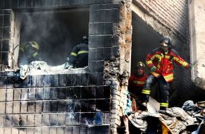 Rescuers work at the site of a direct missile hit on a residential building in the Solomianskyi district of Kyiv