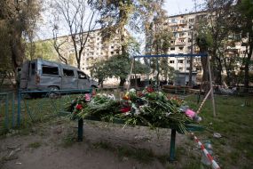 People brought flowers to a residential building in the Solomianskyi district of Kyiv that was hit by a rocket