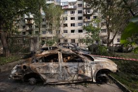 Burnt cars near a residential building in the Solomianskyi district of Kyiv that was hit by a rocket