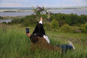 Участники празднования Ивана Купала делают фото с венком из полевых цветов