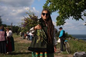 Участница празднования Ивана Купала с букетом из полевых цветов