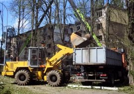 Працівники комунального господарства прибирають сміття і завали біля знищеного ворожою ракетою під'їзду в житловому будинку в Шевченківському районі Києва