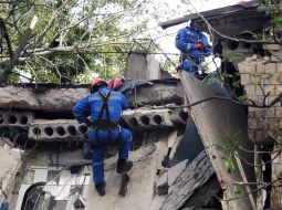 Рятувальники розбирають завали знищеного ворожою ракетою під'їзду в житловому будинку в Шевченківському районі Києва