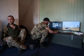 Military personnel train to shoot down aerial targets on a special simulator