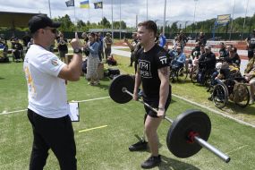 A participant in the "Hero Games" competition lifts a barbell