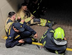 Rescuers hide at a light rail stop during a nighttime mass attack in the Sviatoshynskyi district of Kyiv