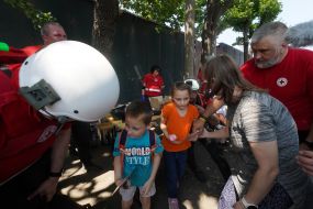 Children near representatives of the Red Cross Society