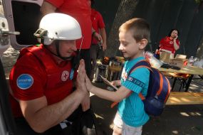 Children near representatives of the Red Cross Society