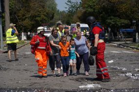 Children near representatives of the Red Cross Society