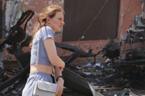 Woman near a destroyed building