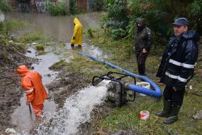 State Emergency Service workers pump water into the sewer in Lviv