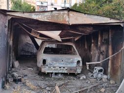 A completely burned-out car in a garage after massive shelling in the Svyatoshynskyi district of Kyiv