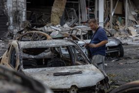 Мужчина возле сожженного автомобиля после ночной атаки беспилотников в Одессе