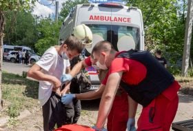 Medics examine a victim injured in the shelling of a TB clinic