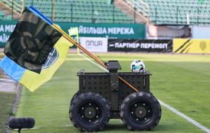 Дистанционно управляемый военный робот Центра специальных операций вывозит на поле футбольный мяч перед матчем