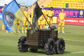 Дистанционно управляемый военный робот Центра специальных операций вывозит на поле футбольный мяч перед матчем