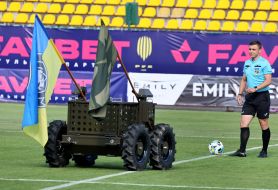 Дистанционно управляемый военный робот Центра специальных операций вывозит на поле футбольный мяч перед матчем