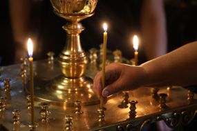 Девушка ставит свечу в Михайловском соборе