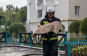 A rescuer carries a dead child