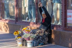 An elderly woman sells flowers