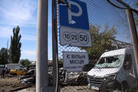 Burnt cars in a parking lot after night shelling in the Darnytskyi district of Kyiv