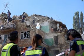 Rescuers continue search and rescue operations in the ruins of a five-story residential building after nighttime shelling in the Darnytskyi district of Kyiv