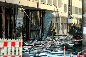 Fragments of window frames and glass on the ground near a house after night shelling in Kyiv