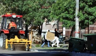 Residents remove belongings from a house damaged after nighttime shelling in Kyiv
