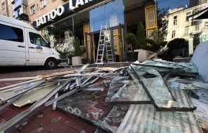 Fragments of window frames and glass on the ground near a house after night shelling in Kyiv