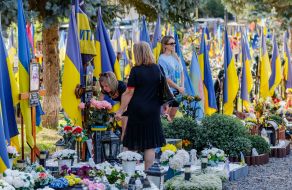 Women lay flowers at the graves of soldiers