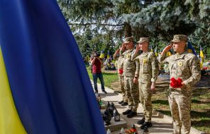 Military personnel lay flowers at the graves of their comrades