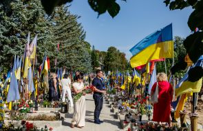 Women lay flowers at the graves of soldiers