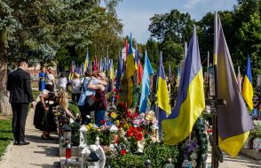 Women lay flowers at the graves of soldiers