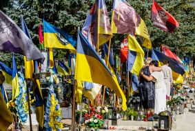 Women lay flowers at the graves of soldiers