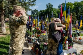 Military personnel lay flowers at the graves of their comrades