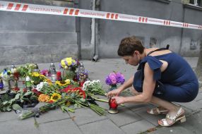 People bring flowers and lamps to the site of Andriy Parubiy's murder in Lviv