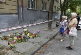 People bring flowers and lamps to the site of Andriy Parubiy's murder in Lviv