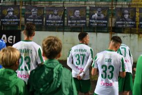Players of FC Karpaty (Lviv) thank fans near portraits of fallen military on the stand