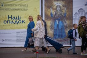 Люди проходят мимо баннера в центре Киева
