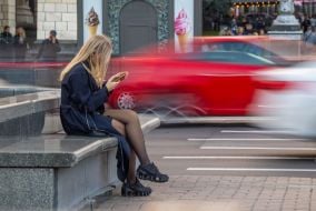 A girl is resting on a granite bench in the center of Kyiv