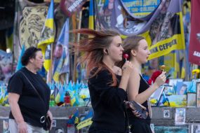 Девушки проходят возле флажков в память о погибших защитниках Украины