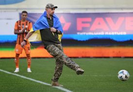 A soldier makes a symbolic kick at the ball