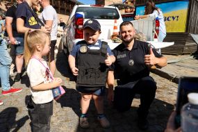 A boy tries on a police officer's body armor