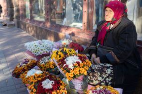 An elderly woman sells bouquets of flowers on the street in the center of Kyiv