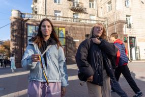 Young women offer passersby ribbons in the colors of the Ukrainian flag on a street in central Kyiv