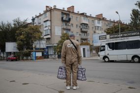 A man with bags on the street in Kherson.