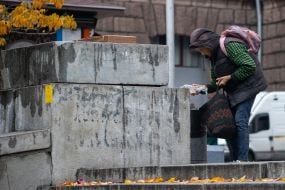 Elderly woman near a garbage dump in the center of Kyiv