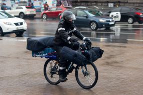 Pizza delivery service courier on a bicycle on the street in Kyiv
